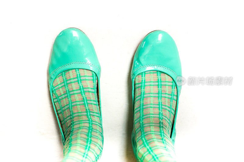 女人的脚站在海蓝宝石/绿色高跟鞋
